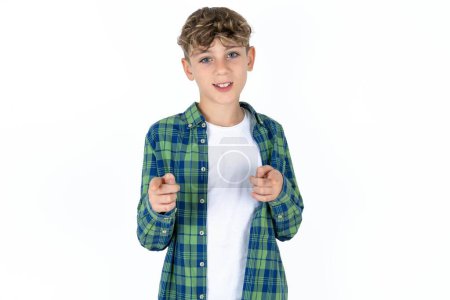 Téléchargez les photos : Beau adolescent garçon portant chemise à carreaux sur fond blanc pointant les doigts vers la caméra avec visage heureux et drôle. Bonne énergie et vibes. - en image libre de droit