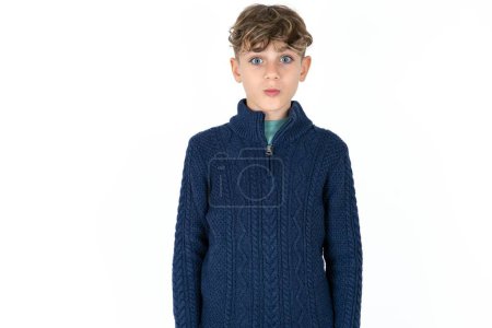Photo for Shot of pleasant looking Handsome Caucasian teen boy in blue sweater pouts lips, looks at camera, Human facial expressions - Royalty Free Image