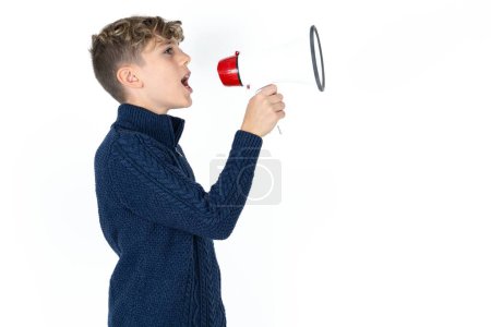 Téléchargez les photos : Beau caucasien adolescent garçon en bleu pull par mégaphone avec disponible copie espace - en image libre de droit
