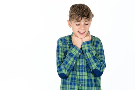 Photo for Satisfied handsome teen boy wearing plaid shirt over white background touches chin with both hands, smiles pleasantly, rejoices good day with lover - Royalty Free Image