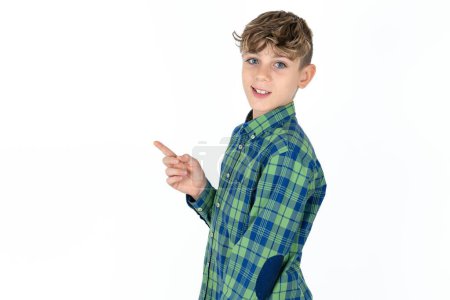 Profile photo of handsome teen boy wearing plaid shirt over white background indicate finger empty space offer