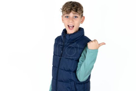 Photo for Impressed Handsome Caucasian teen boy in blue vest point back empty space - Royalty Free Image