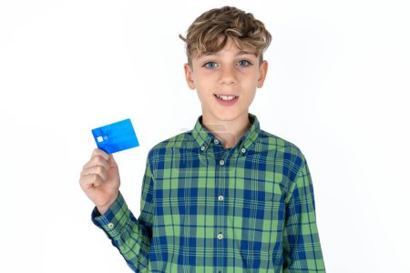 Photo for Photo of happy cheerful smiling positive handsome teen boy wearing plaid shirt over white background recommend credit card - Royalty Free Image