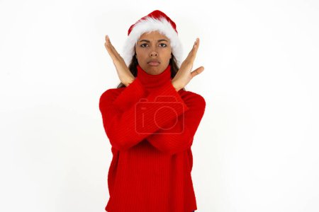 Téléchargez les photos : Jeune belle femme portant un pull rouge et santa claus chapeau à Noël expression de rejet croisant les bras faisant signe négatif, visage en colère - en image libre de droit
