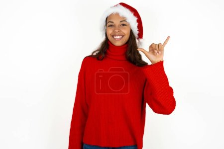 Foto de Joven hermosa mujer vistiendo suéter rojo y sombrero de Santa Claus en Navidad que muestra el número seis Liu con el gesto de los dedos en el lenguaje chino signo - Imagen libre de derechos