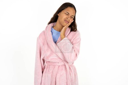 Photo for Young woman wearing pink bathrobe over white background with toothache - Royalty Free Image