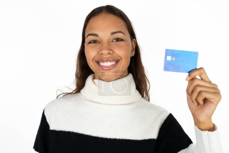 Photo for Photo of happy cheerful smiling positive young beautiful woman wearing striped sweater on white background recommend credit card - Royalty Free Image