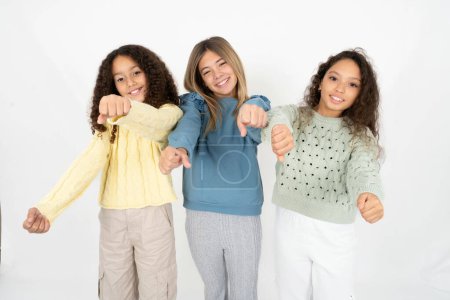 Photo for Three young beautiful multiracial kid girls imagine steering wheel helm rudder passing driving exam good mood fast speed - Royalty Free Image