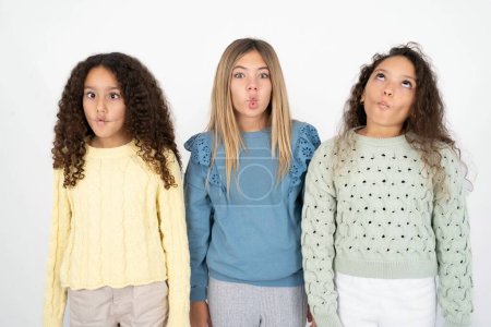 Photo for Three young beautiful multiracial kid girls making fish face with lips, crazy and comical gesture. Funny expression. - Royalty Free Image