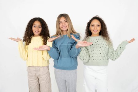 Téléchargez les photos : Enthousiaste joyeux optimiste Trois jeunes belles jeunes filles multiraciales tenant des paumes de copie espace - en image libre de droit