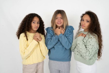 Photo for Three young beautiful multiracial kid girls desperate and depressed with tears on their eyes suffering pain and depression  in sadness facial expression and emotion concept - Royalty Free Image