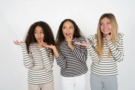Foto de Positivo Tres jóvenes hermosas niñas multirraciales anuncio promocional toque los dientes de los dedos - Imagen libre de derechos