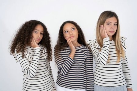 Téléchargez les photos : Photo de trois jeunes belles filles multiraciales jouissent d'une peau fraîche et lisse toucher visage - en image libre de droit