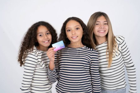 Photo for Photo of happy cheerful smiling positive Three young beautiful multiracial kid girls recommend credit card - Royalty Free Image