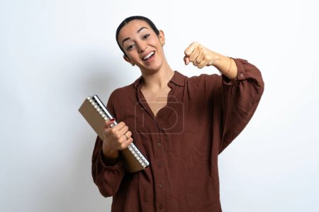 Foto de Hermosa mujer árabe estudiante lleva cuadernos con papel imaginar timón timón timón pasar examen de conducción buen humor velocidad rápida - Imagen libre de derechos