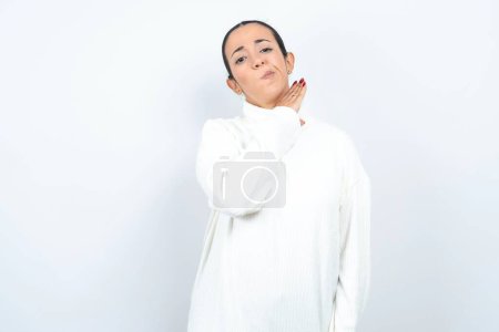 Foto de Hermosa mujer árabe posando sobre fondo blanco degollando con la mano como cuchillo, amenazan la agresión con violencia furiosa. - Imagen libre de derechos
