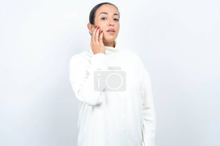Téléchargez les photos : Photo de belle femme arabe posant sur fond blanc profiter d'une peau fraîche et lisse toucher visage - en image libre de droit