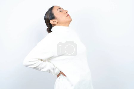 Photo for Beautiful arab woman posing over white background got back pain - Royalty Free Image