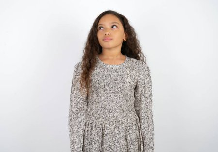 Photo for Beautiful teen girl wearing grey dress over white background looking aside into empty space thoughtful - Royalty Free Image