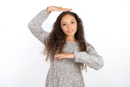 Photo for Beautiful teen girl wearing grey dress over white background gesturing with hands showing big and large size sign, measure symbol. Smiling looking at the camera. - Royalty Free Image