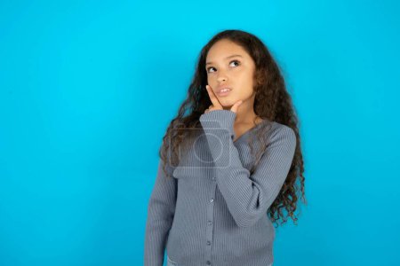 Photo for Beautiful kid girl wearing casual jacket over blue background Thinking worried about a question, concerned and nervous with hand on chin. - Royalty Free Image