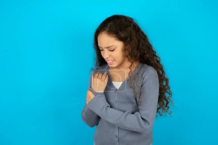 Photo for Beautiful kid girl wearing casual jacket over blue background Suffering pain on hands and fingers, arthritis inflammation - Royalty Free Image