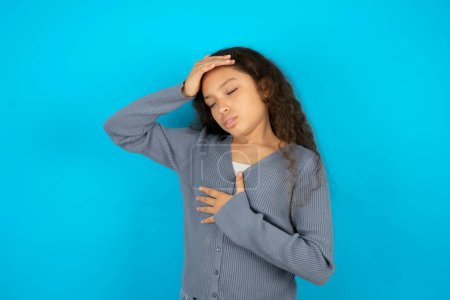 Photo for Beautiful kid girl wearing casual jacket over blue background Touching forehead for illness and fever, flu and cold, virus sick. - Royalty Free Image