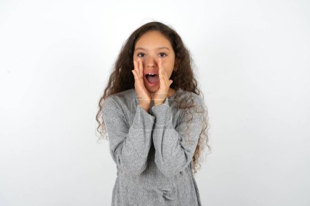 Photo for Beautiful teen girl wearing grey dress over white background shouting excited to front. - Royalty Free Image