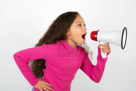 Photo for Funny Beautiful kid girl wearing pink turtleneck over white background People sincere emotions lifestyle concept. Mock up copy space. Screaming in megaphone. - Royalty Free Image