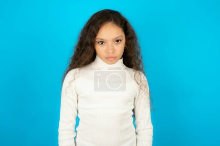 Photo for Beautiful kid girl wearing white turtleneck over blue background Pointing down with fingers showing advertisement, surprised face and open mouth - Royalty Free Image
