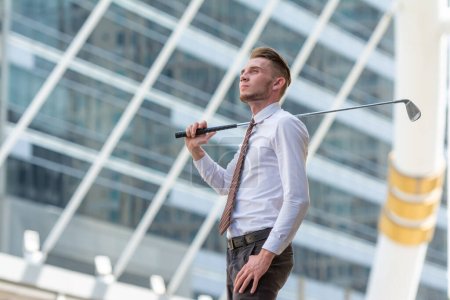 Photo for Successful Young cuacasion confident CEO Businessman wearing white shirt with golf club in the city looking up in the sky with dreamy. - Royalty Free Image