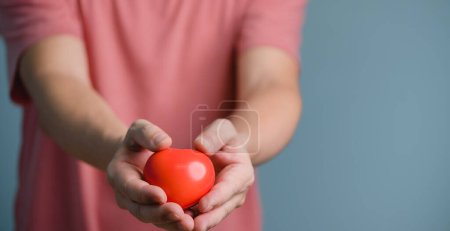 Photo for Hands holding and giving red heart for love, health care, organ donation, world heart day, world health day, mindfulness, well being, family insurance concept - Royalty Free Image