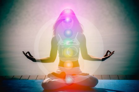 Foto de Mujer aura joven en meditación de yoga con la naturaleza siete chakras y símbolos de Yin Yang. - Imagen libre de derechos