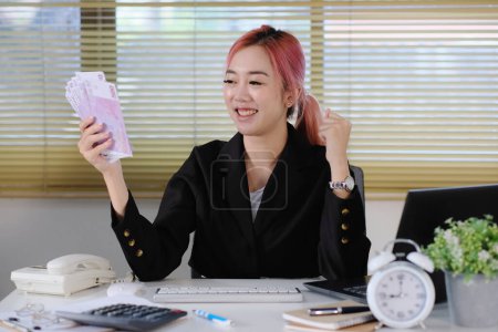 Téléchargez les photos : Asiatique femme d'affaires tenant de l'argent - en image libre de droit