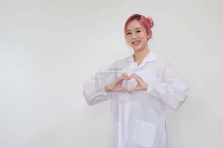 Photo for Woman doctor in hospital, smiling and making a heart shape with her hands - Royalty Free Image