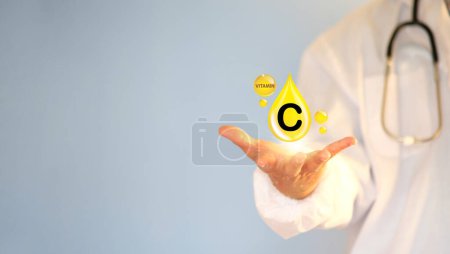Photo for Doctor holding Vitamin C on it. C symbol of the need for vitamins "Vitamin C in food" Natural products rich in vitamin C - Royalty Free Image