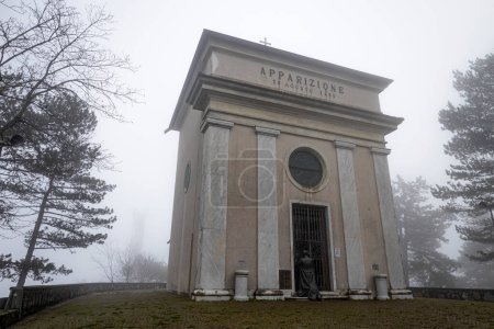 Téléchargez les photos : Chapel of the appearace near the Sanctuary of Our Lady of the Guard (Madonna della Guardia) in the fog, in winter time, in Genoa, Italy. - en image libre de droit