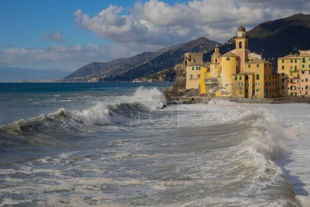 Foto de Mar áspero en la playa de Camogli y la Basílica de Santa Maria Assunta, provincia de Génova, Italia. - Imagen libre de derechos