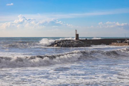 Téléchargez les photos : Rough sea on the pier of Recco with the lighthouse, Genoa province, Italy. - en image libre de droit