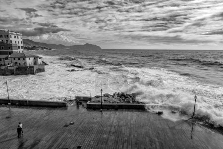 Téléchargez les photos : GENOA, ITALIE 3 NOVEMBRE 2023 - Une journée sombre avec une mer agitée, un ciel avec des nuages à Gênes Boccadasse, photo noir et blanc, Italie - en image libre de droit