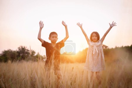 Téléchargez les photos : Silhouette enfant, Moments de joie de l'enfant. Sur le coucher du soleil Nature sur fond doux et flou - en image libre de droit