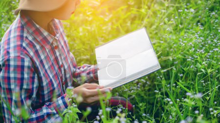 Téléchargez les photos : Femme heureuse allongée sur l'herbe verte lisant un livre dans le parc (en plein air) SSTKHome - en image libre de droit