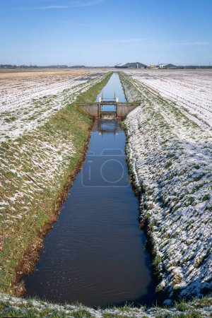 Téléchargez les photos : Paysage typiquement néerlandais avec prairies, neige, fermes, fossés et écluses pour maintenir le niveau d'eau, province de Drenthe, Pays-Bas - en image libre de droit