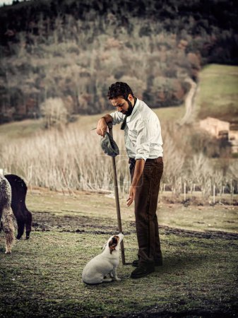 Foto de Shepherd juega con el perro al final de un día agotador. - Imagen libre de derechos