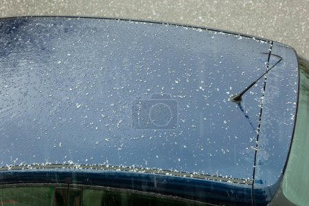 Foto de Hail falling over car roof. Hailstones can damage the bodywork. - Imagen libre de derechos