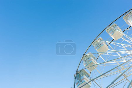 Téléchargez les photos : Grande roue sur le fond bleu ciel. Attraction présente dans les parcs d'attractions. - en image libre de droit