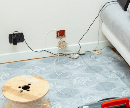 Téléchargez les photos : Passage de câbles à fibre optique dans l'appartement avec remplacement de la prise téléphonique traditionnelle. - en image libre de droit
