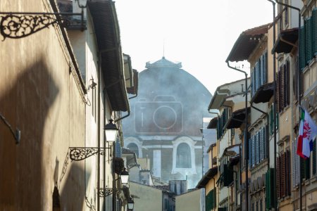 Foto de Vista parcial de la cúpula de Brunelleschi en Florencia. Vista inusual en un vistazo a un callejón. Foto tomada en invierno. - Imagen libre de derechos