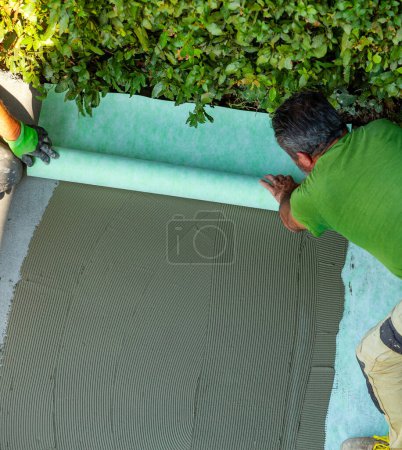 Photo for Laying a sound-absorbing mat on the screed. - Royalty Free Image