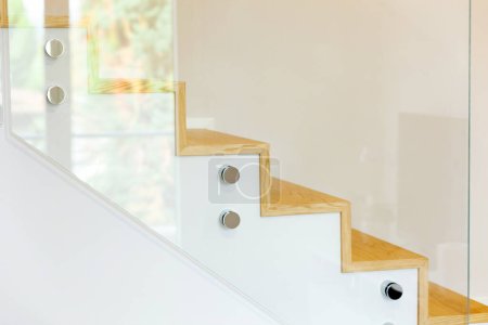 Téléchargez les photos : Escalier recouvert de parquet en chêne avec balustrade en verre trempé et broches chromées. - en image libre de droit